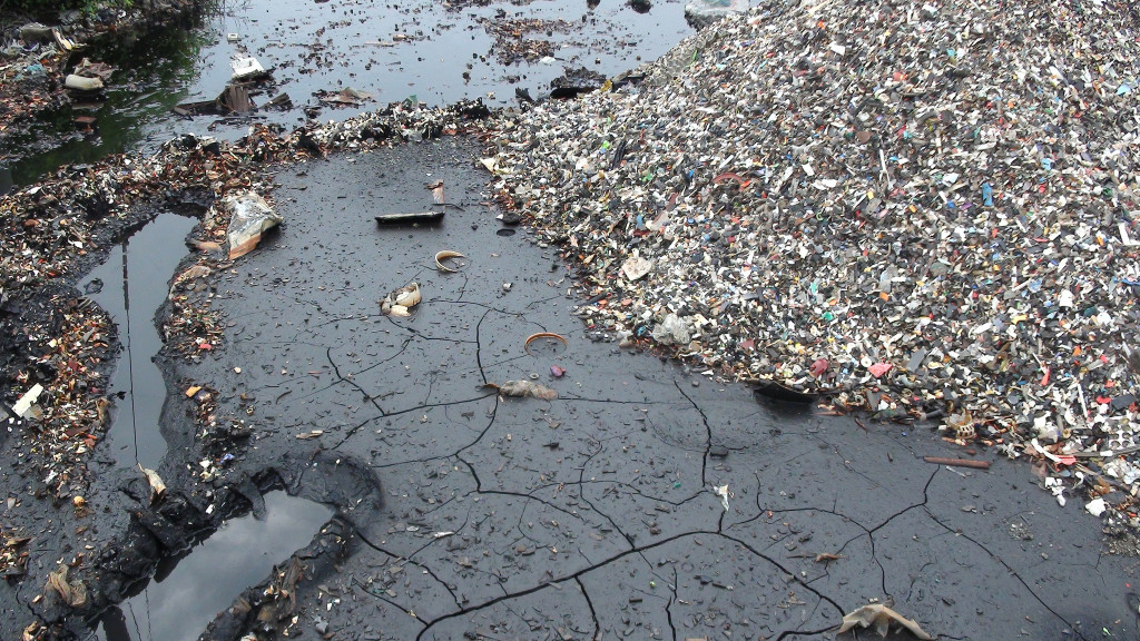 Toner leaking into a stream. Guiyu, China