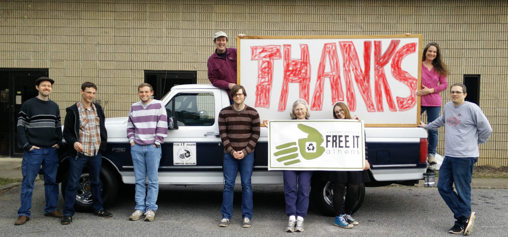 a group of volunteers stand with a sign that says "Thanks"