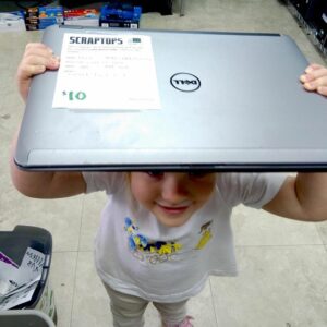 a toddler holding up a laptop