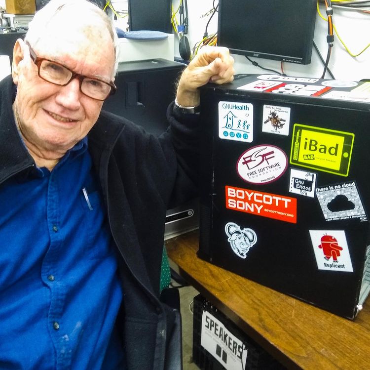 a volunteer with a computer covered in colorful stickers