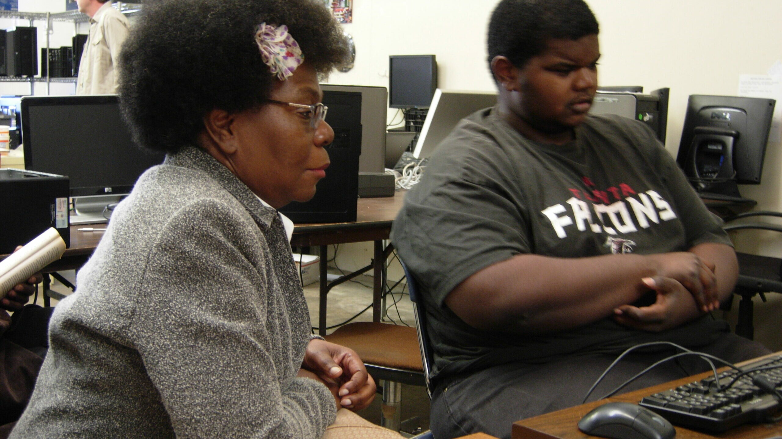 two people work at a desk in front of a computer