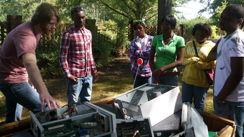 a group of volunteers around a Gaylord full of ewaste recycling